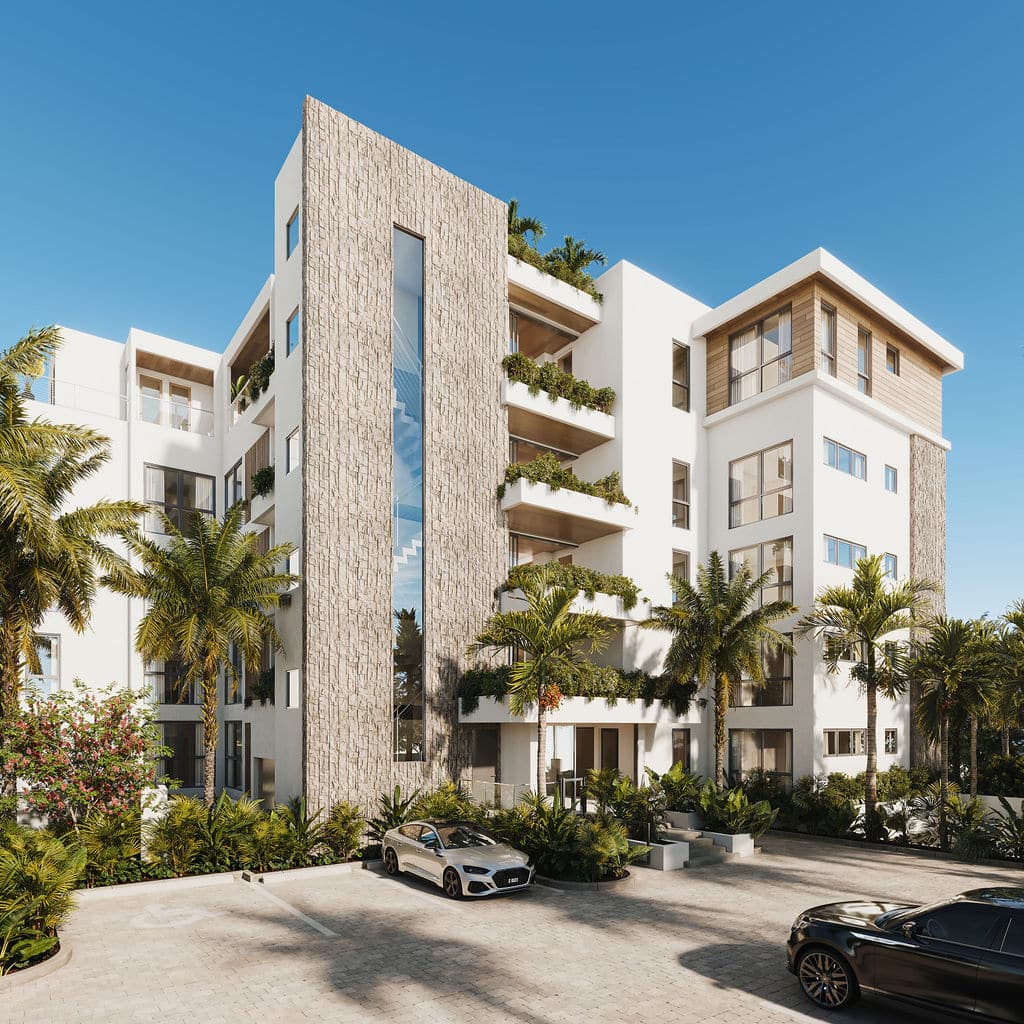 Modern multi-story apartment building with large windows, stone accents, and balconies with greenery. Palm trees and landscaped plants surround the entrance, with luxury cars parked in front under a clear blue sky.